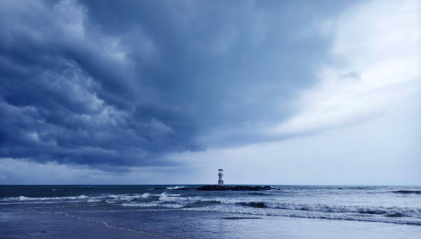A solitary lighthouse stands in the ocean.