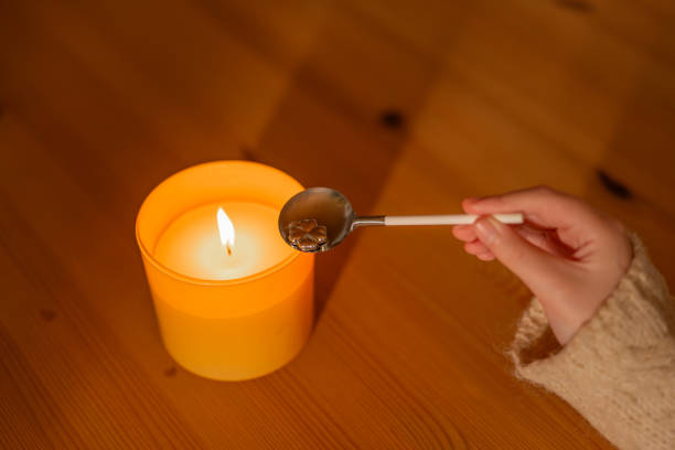 tin casting set for New Years party.Hand holding spoon with tin figurine over candle flame.Top view.spoon and tin figurines on a wooden table.lead pouring set for fortune telling conjunto de fundición de hojalata para la fiesta de año nuevo. cuchara de mano con figurita de hojalata sobre la llama de la vela. vista superior.figuritas de cuchara y lata en una mesa de madera. conjunto de vertido de plomo para adivinación