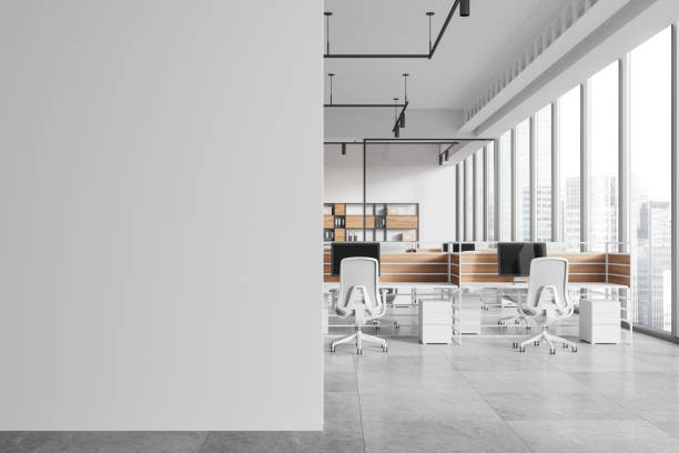 istock White business interior with desks and pc computers in row, window. Mockup wall 2175391350