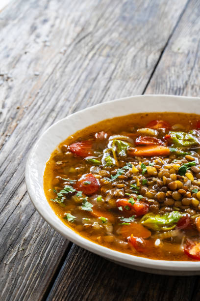 istock Fresh vegetable soup with lentil served in white bowl on wooden table 2175391494