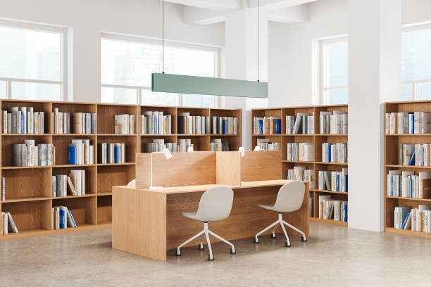 istock Stylish library interior with work tables in row and bookshelf, panoramic window 2175392737