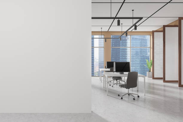 istock Office workplace interior with pc monitors on tables in row, window. Mockup wall 2175392757