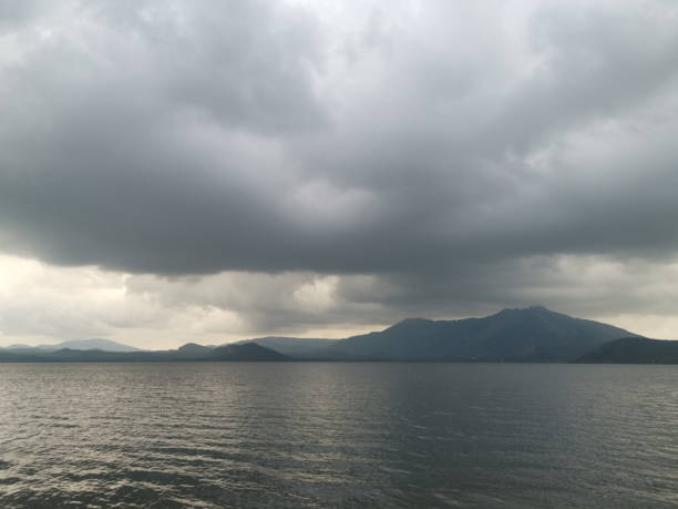 Large body of water with a cloudy sky above it. The sky is dark and the water is calm