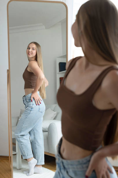 istock Smiling woman is looking at mirror with positive emotion 2175396702