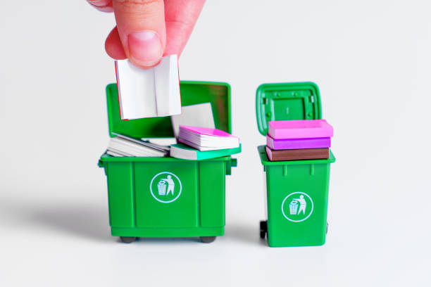 istock Miniature Hand Disposing Books in Green Trash Bins on White Background 2175396901