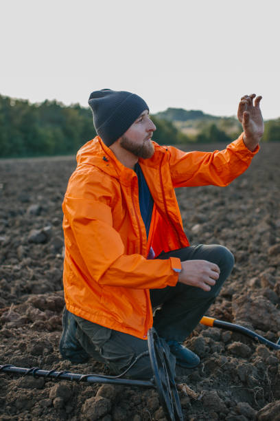 istock A young man is a treasure hunter. A man holds an ancient coin found with a metal detector. 2175402083