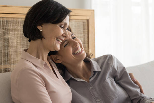 istock Grown up daughter and mature mother hugging seated on sofa 2175402691