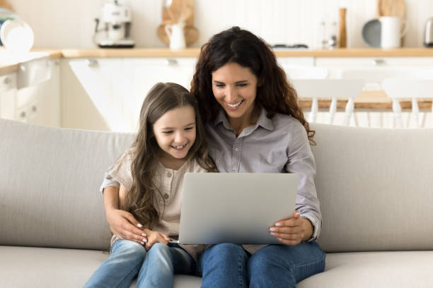 istock Mother and kid spend family leisure on internet using laptop 2175403563