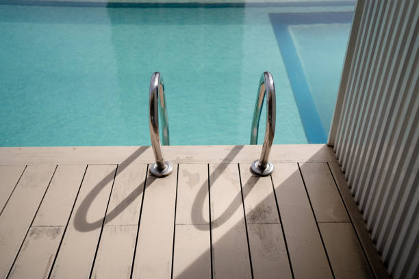 istock Close up swimming pool grab bar ladder illuminated by sunlight. 2175404428