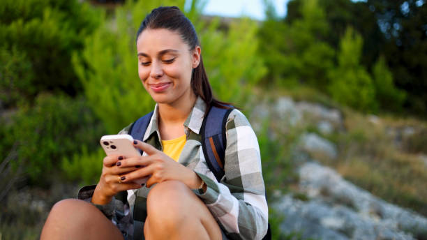 istock Beautiful girl on a hike chilling and using smartphone 2175404443