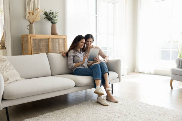 istock Young adult daughter and mature mother using digital tablet 2175405683