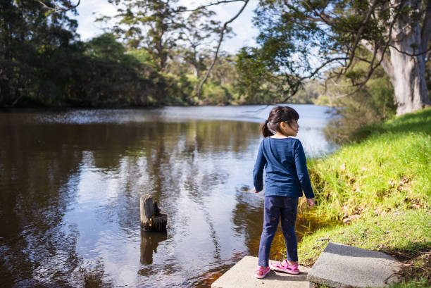 young girl enjoying traveling and looking at river