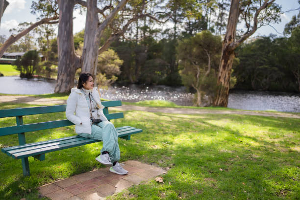 woman  sitting on grass and looking at river