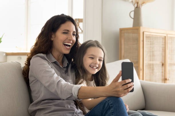 istock Laughing mom and kid using cellphone enjoy videocall 2175405879