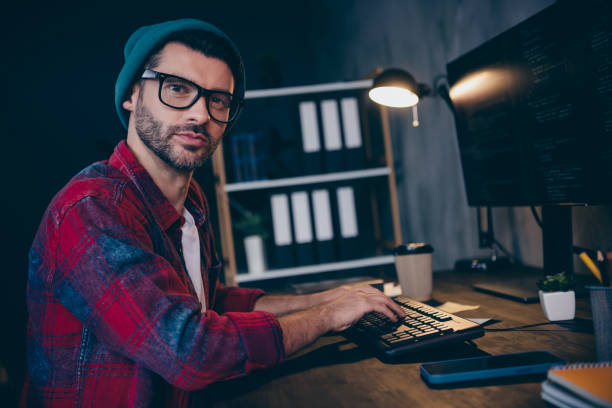 istock Photo of cool serious coder dressed hat glasses fulfilling task modern gadget indoors workplace workstation loft 2175408151