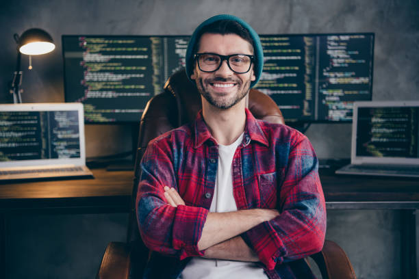 istock Photo of good mood happy coder dressed hat glasses smiling arms folded indoors workplace workstation loft 2175408233