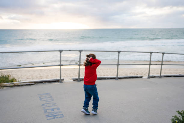kid walking and looking out to sea