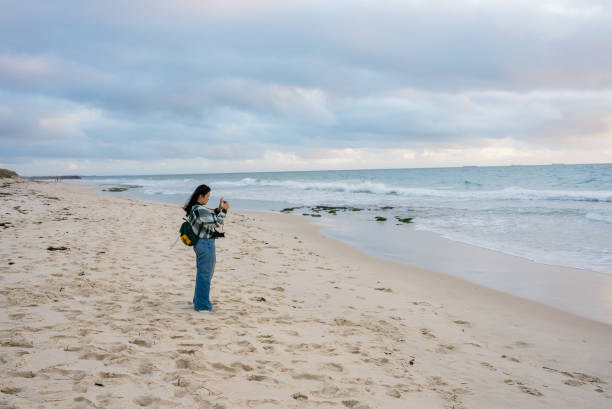 istock woman walking and looking out to sea 2175411219