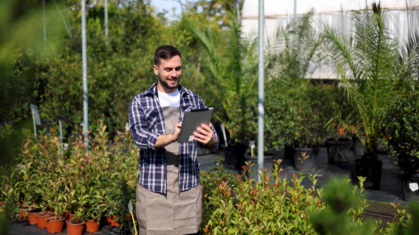 istock Agricultural engineer using a digital tablet and planning planting at the garden center 2175412219