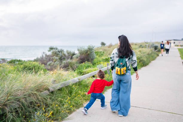asian family walking and  looking at beach