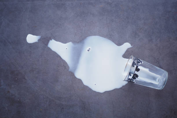 Spilled white milk on a black background .