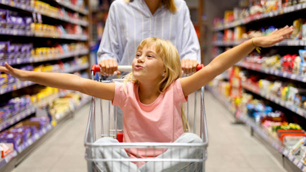 istock Cheerful girl having fun while shopping with mom at the supermarket 2175431482
