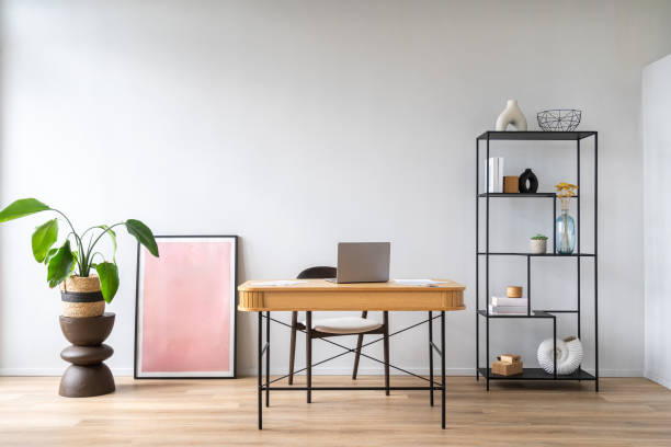 istock Modern workspace with a stylish wooden desk, art work, potted plant and open shelving 2175431577