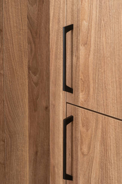 Wooden cabinet with black handles in a modern interior setting