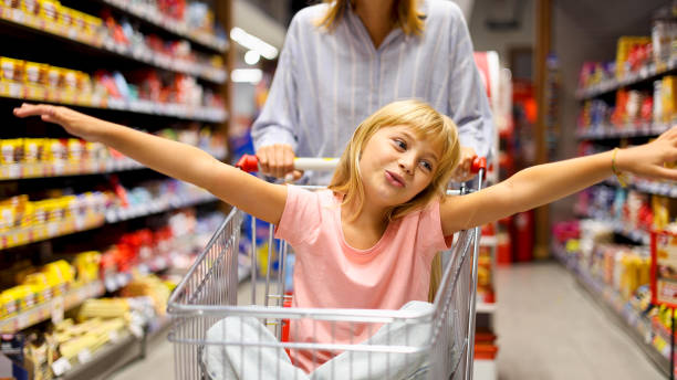 istock Cheerful girl having fun while shopping with mom at the supermarket 2175431612
