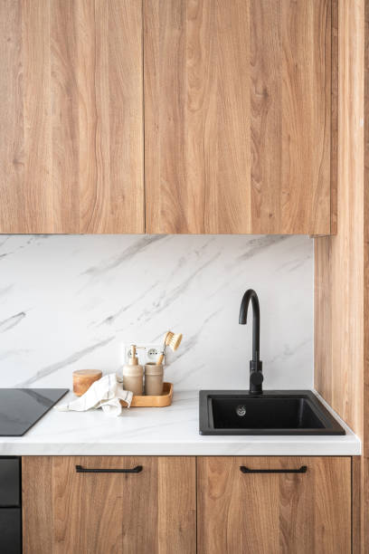 istock Modern kitchen with wooden cabinets and sleek black sink in a cozy home setting 2175431622
