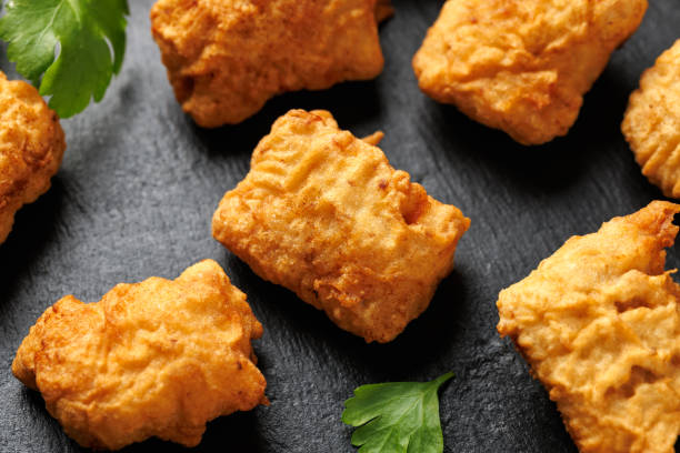 istock Homemade crispy fried chicken nuggets served on a stone board 2175436827