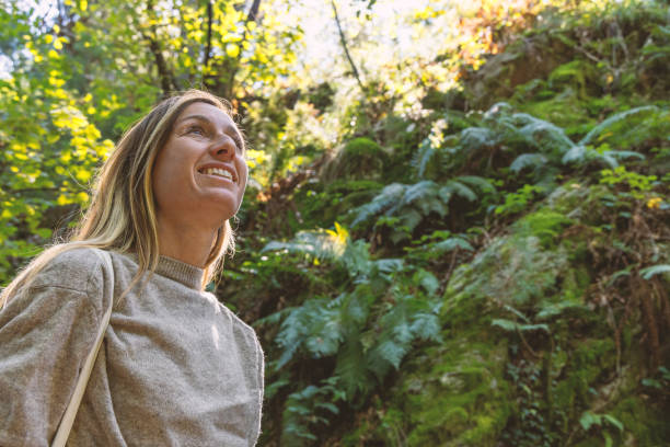 istock Happy young woman enjoying the sunlit forest 2175437613