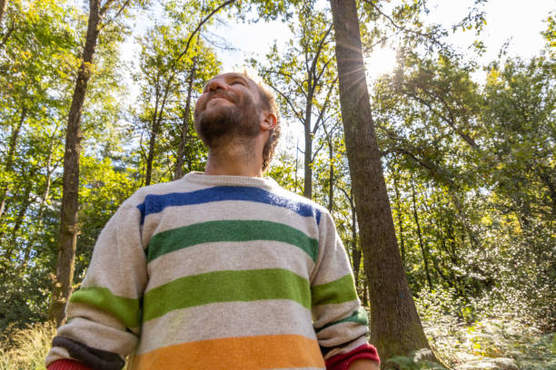 istock Man Enjoying Nature in Sunlit Forest 2175437815