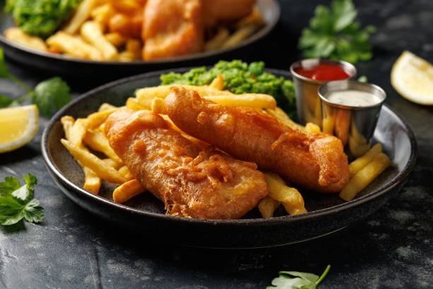 ikan dan keripik inggris dengan kacang polong tumbuk, tartar, dan saus tomat. - ikan kod foto potret stok, foto, & gambar bebas royalti