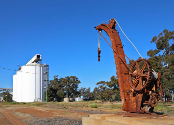 istock Old, rusty, historic, mechanical crane next to unused railway tracks, with grain silos in background. Clear blue sky, Western Australian Wheatbelt region. Outback. 2175450723
