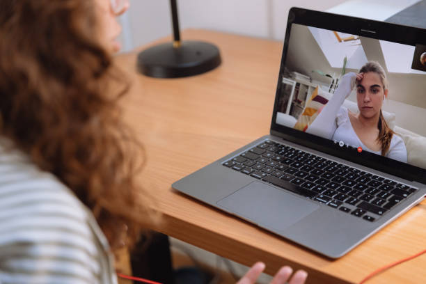 istock Therapist Talking to Patient on Video Call - View from Over Therapist’s Shoulder 2175451544