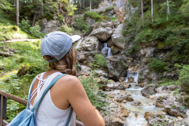 istock Woman Admiring Rocky Waterfall in Forest 2175455913