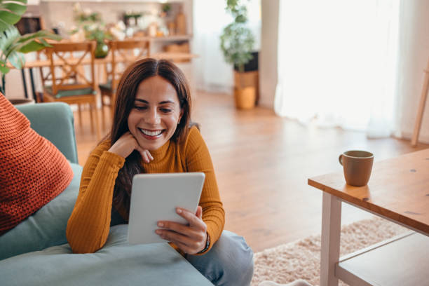 istock Smiling Woman Using Tablet in Cozy Living Room Setting 2175460140