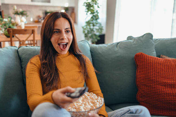 istock Woman Relaxing on Sofa Watching TV with Popcorn 2175460166