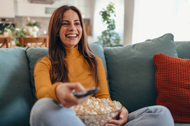 istock Woman Relaxing on Sofa Watching TV with Popcorn 2175460221