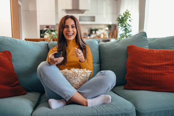istock Woman Relaxing on Sofa Watching TV with Popcorn 2175460227
