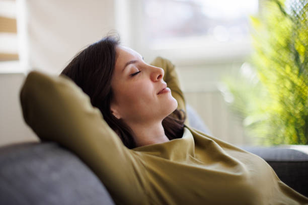 istock Happy smiling woman relaxing on sofa at home 2175461797