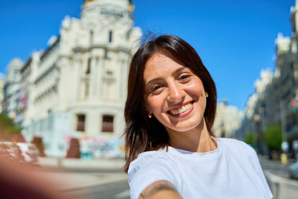 istock Young woman smiling while taking a selfie in Madrid 2175470655