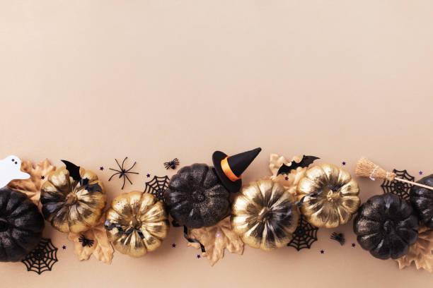 istock Halloween pumpkins with party decorations on golden background top view. 2175485482