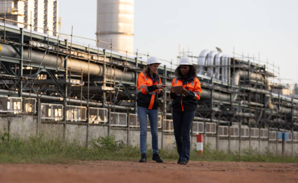 istock International women's day. Two brilliant female engineers engaged in a dynamic discussion at a bustling refinery plant in the heart of the industry. Embracing diversity and driving innovation in engineering. 2175487811