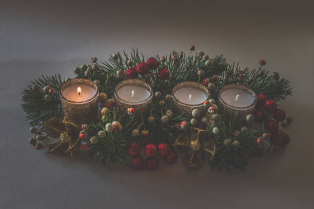 istock advent decoration, ikebana with four candles, first candle flame 2175489558