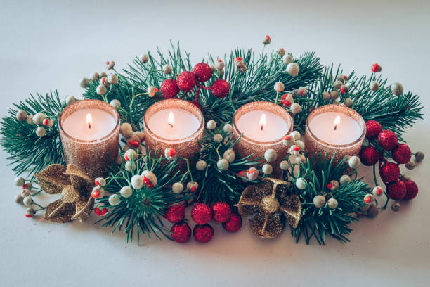 istock advent decoration, ikebana with four candles burning, green red tone 2175489559