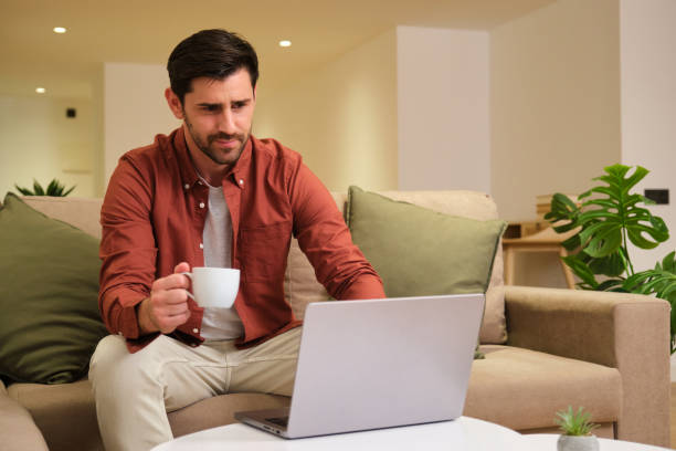 istock Focused freelancer working from home on laptop and holding coffee cup 2175492822