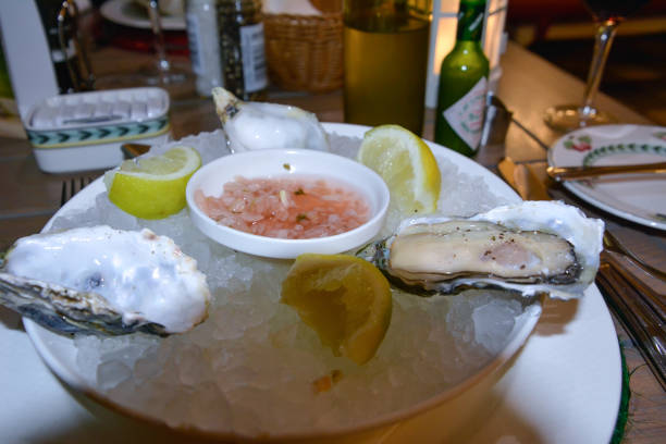 istock Several oyster shells on a plate with ice and lemon close-up. Menu of restaurants and cafes 2175493814