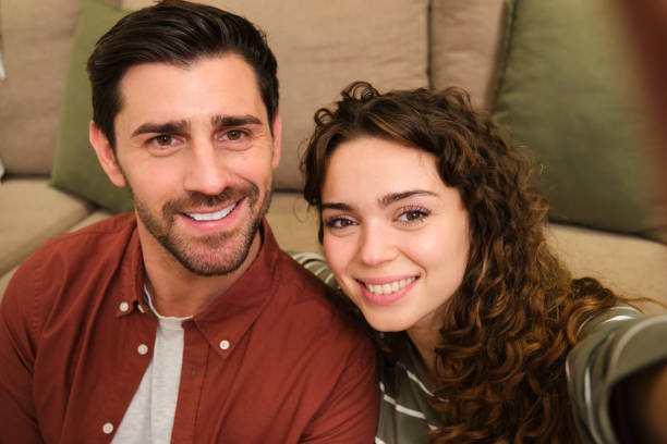 istock Happy couple smiling while relaxing on sofa at home 2175493875